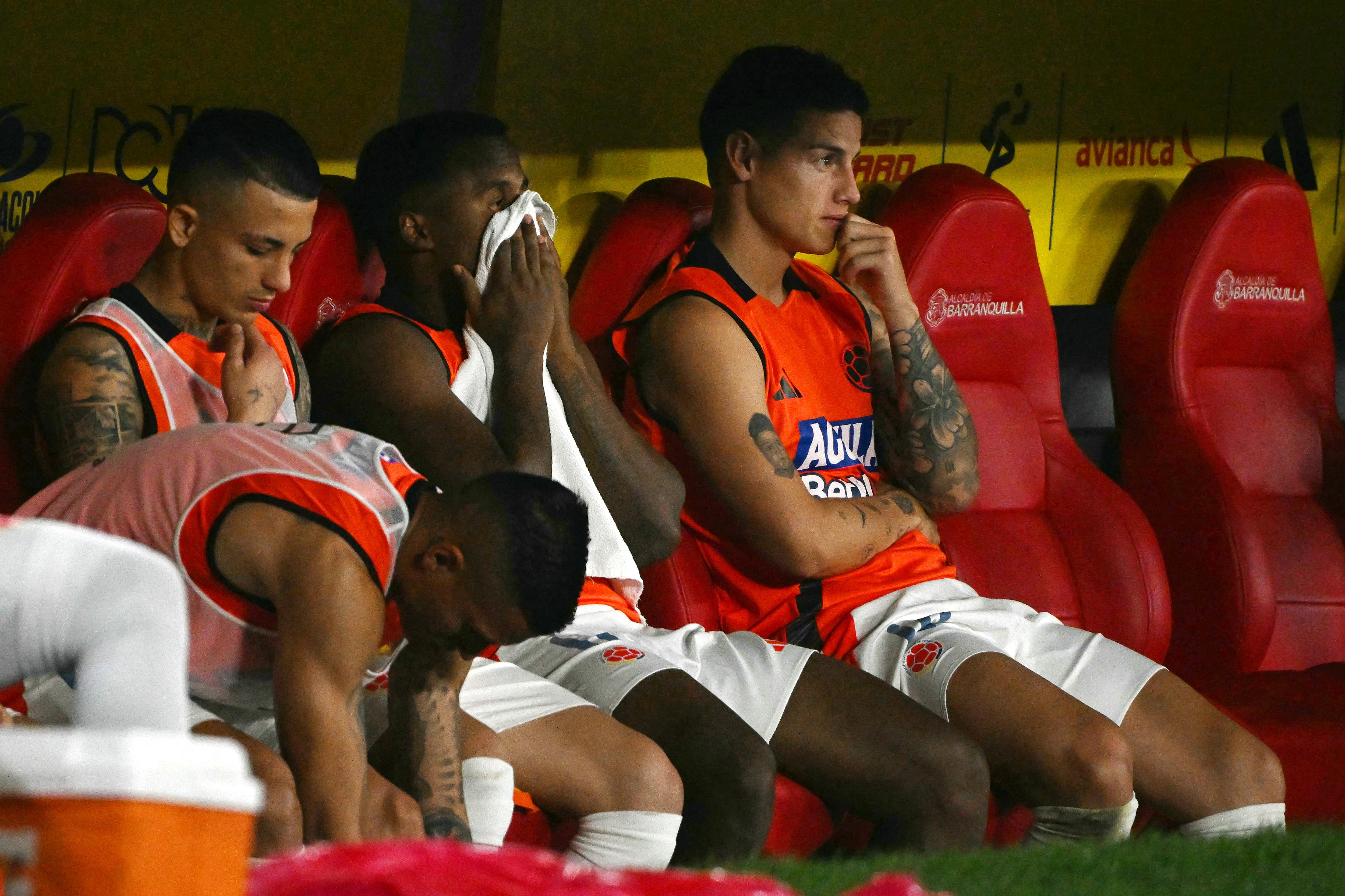 Colombia's forward #11 Jhon Arias (2nd-R) and teammate midfielder #10 James Rodriguez (R), gesture as they watch the game on the bench during the 2026 FIFA World Cup South American qualifiers football match between Colombia and Paraguay at the Metropolitano Roberto Melendez stadium in Barranquilla, Colombia, on March 25, 2025. (Photo by Luis ACOSTA / AFP)