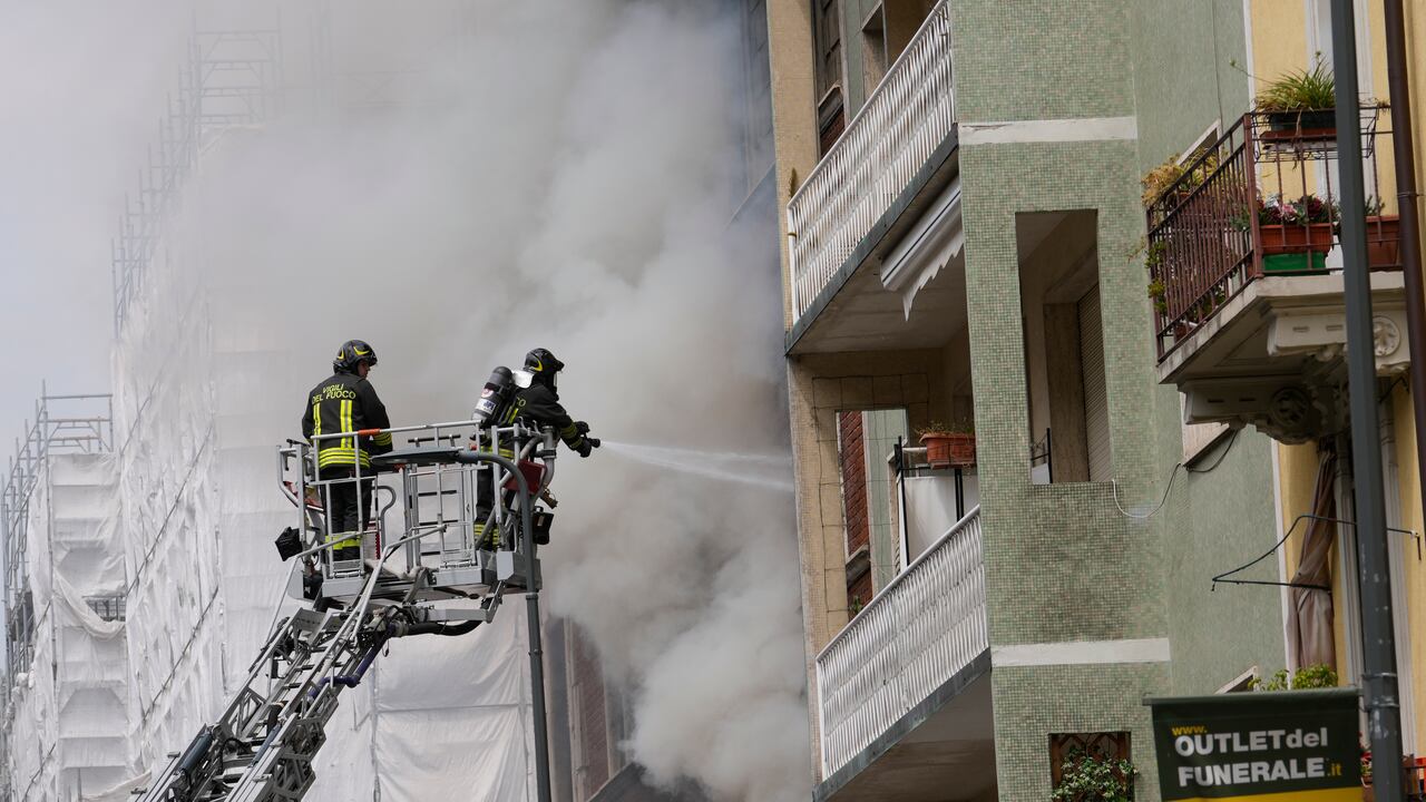 Los bomberos trabajan para extinguir un incendio en un edificio luego de que una camioneta explotara en el centro de Milán, norte de Italia, el jueves 11 de mayo de 2023.