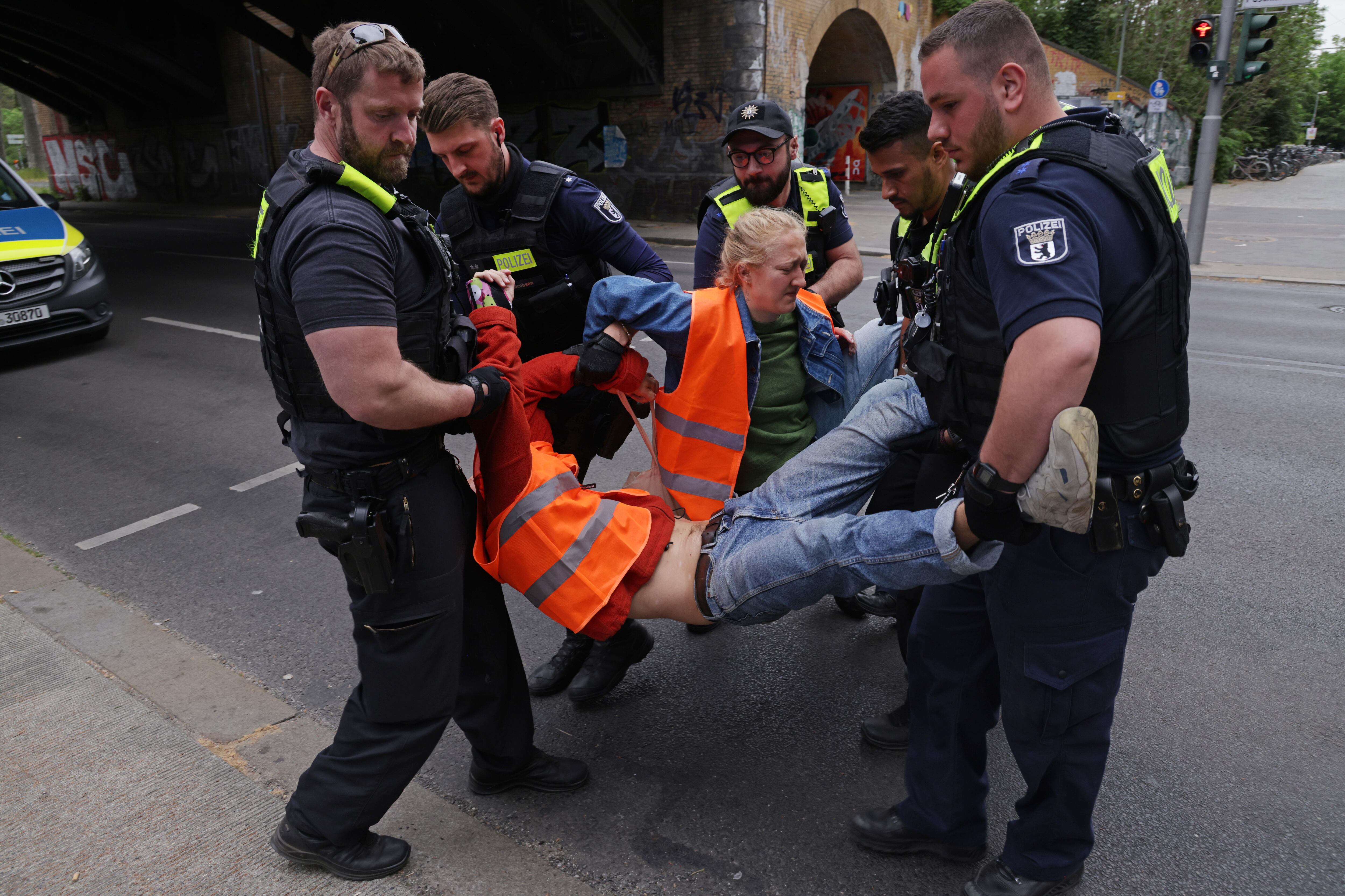 Miembro del grupo ambientalista Última Generación siendo llevado por las autoridades después de una protesta.