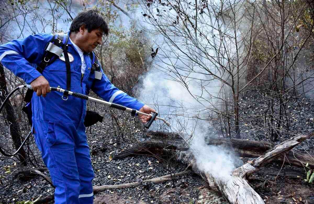 El presidente boliviano Evo Morales rocía agua en un incendio en las afueras de Roboré, Bolivia, el martes 27 de agosto de 2019. (Raúl Martínez / Oficina de prensa del Ministerio de Comunicación de Bolivia a través de AP)