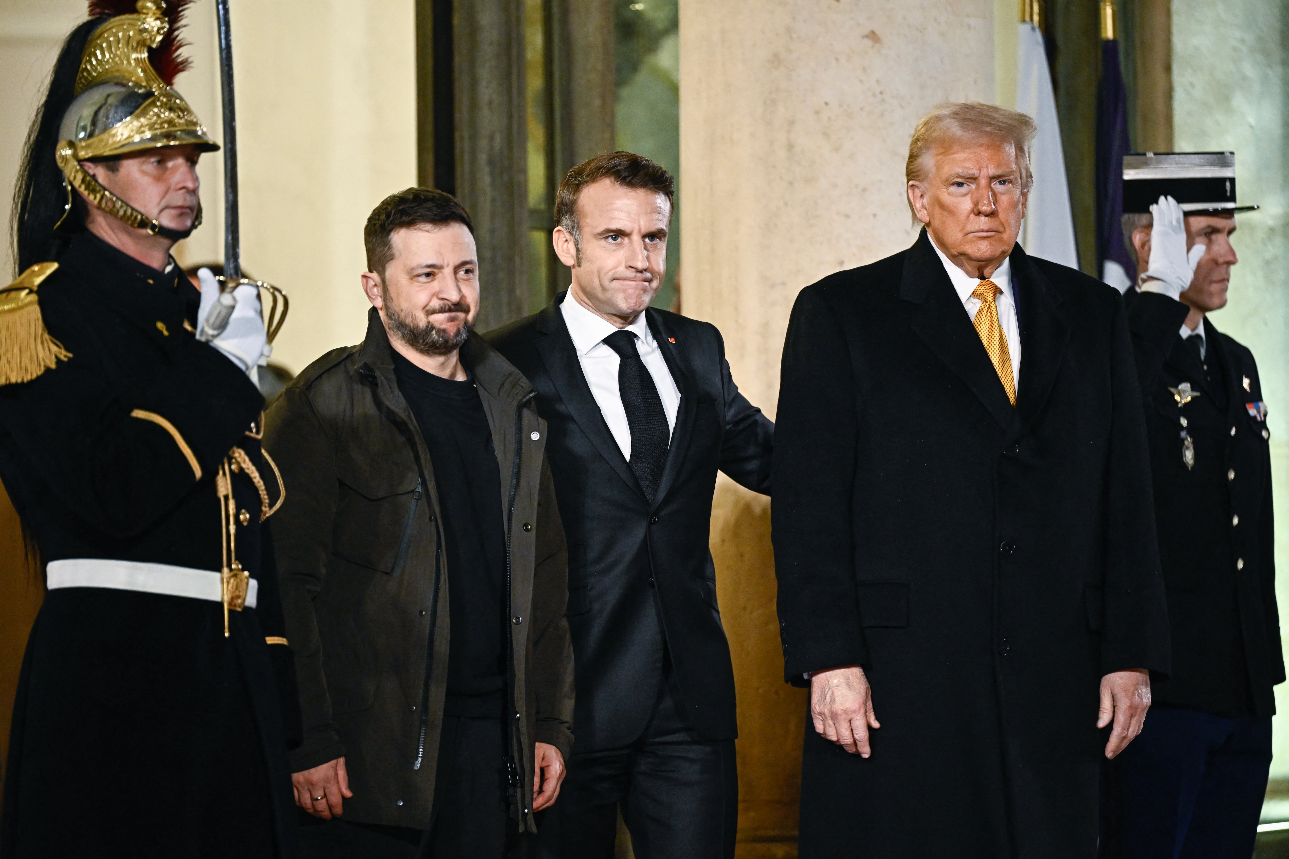 El presidente de Francia, Emmanuel Macron, flanqueado por el presidente electo de Estados Unidos, Donald Trump, y el presidente de Ucrania, Volodymyr Zelensky, se van después de una reunión en el Palacio Presidencial del Elíseo en París el 7 de diciembre de 2024.