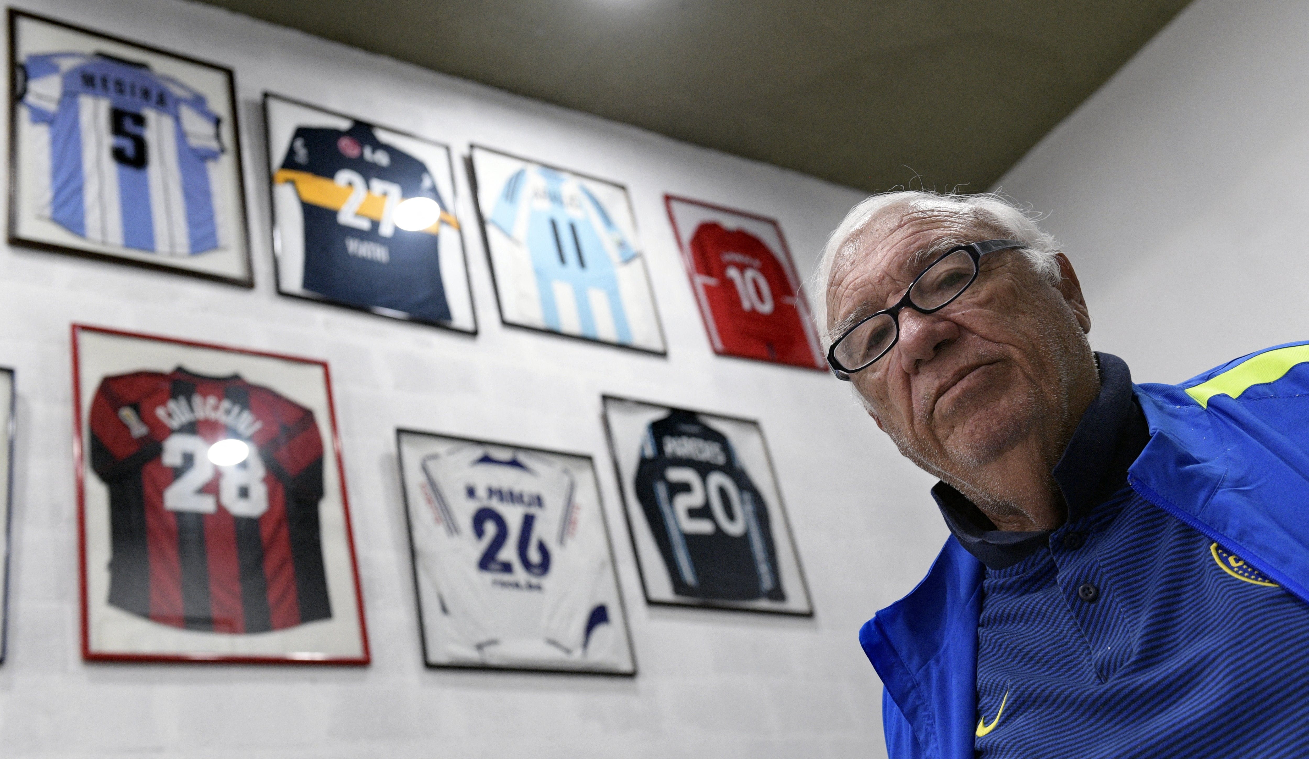 Argentinian football talent scout Ramon Maddoni poses next to jerseys given to him by football stars he scouted at Club Parque in Buenos Aires on March 22, 2018. Maddoni is a legend among football talent scouts. Over 100 players were scouted by him, including Carlos Tevez -who played in Argentinian Boca Juniors, Manchester United, Manchester City and Italian Juventus-, Fernando Redondo -who played in Spanish Real Madrid and Italian Milan- and Esteban Cambiasso -who played in Spanish Real Madrid and Italian Inter. (Photo by JUAN MABROMATA / AFP) / TO GO WITH AFP STORY BY DANIEL MEROLLA