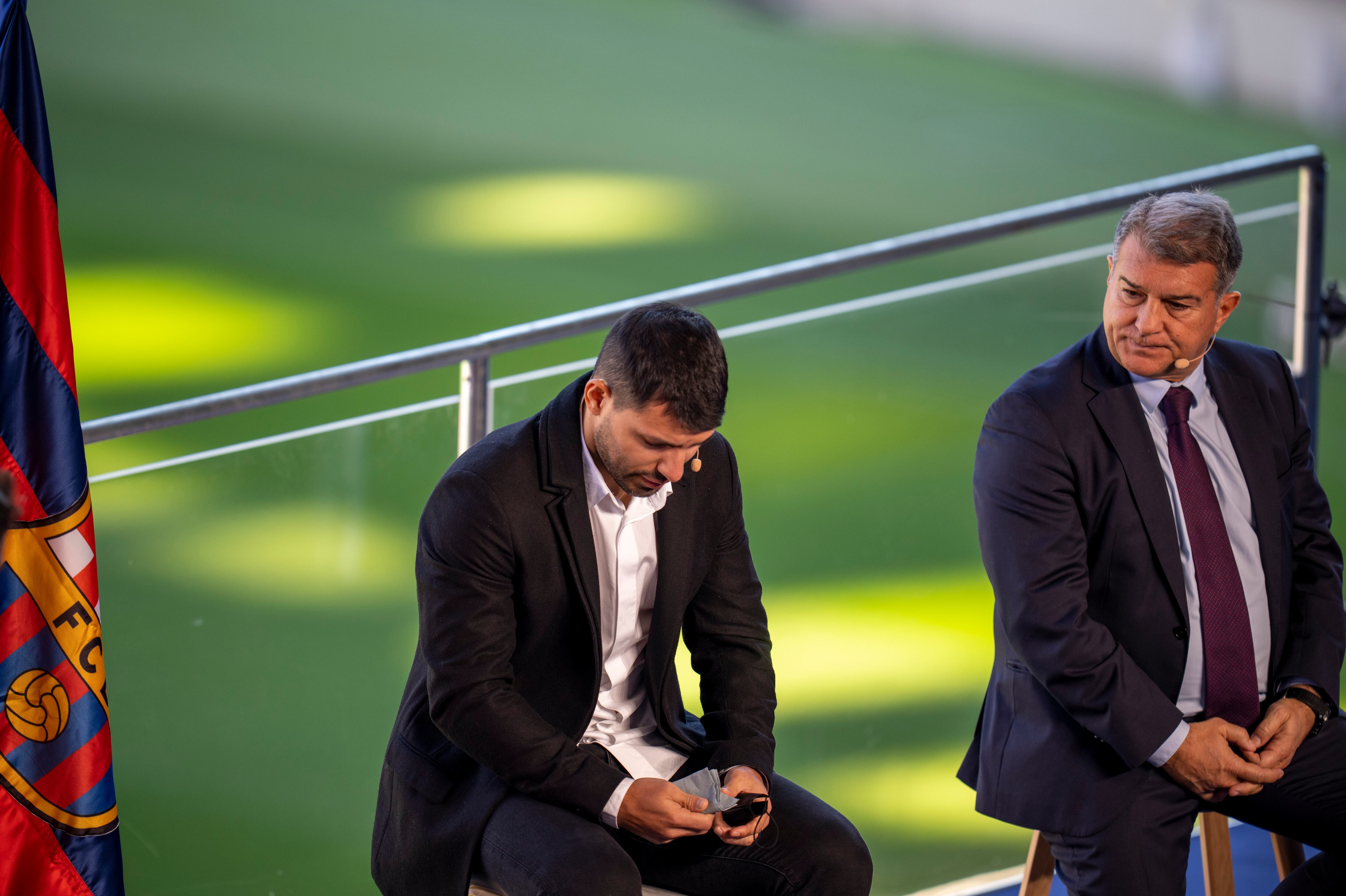 Barcelona striker Sergio Aguero reacts next to Barcelona president Joan Laporta during a press conference at the Camp Nou stadium in Barcelona, Spain, Wednesday, Dec. 15, 2021. Sergio Aguero has announced his retirement from football on Wednesday due to a heart condition. (AP Photo/Emilio Morenatti)