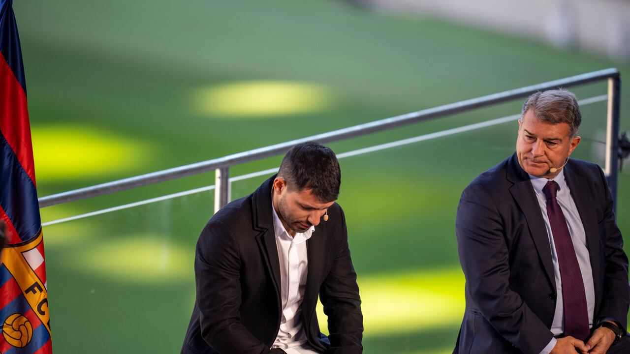 Barcelona striker Sergio Aguero reacts next to Barcelona president Joan Laporta during a press conference at the Camp Nou stadium in Barcelona, Spain, Wednesday, Dec. 15, 2021. Sergio Aguero has announced his retirement from football on Wednesday due to a heart condition. (AP Photo/Emilio Morenatti)
