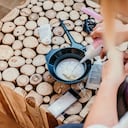 Mano de mujer vertiendo tinte para el cabello mezcla de ingredientes en un tazón