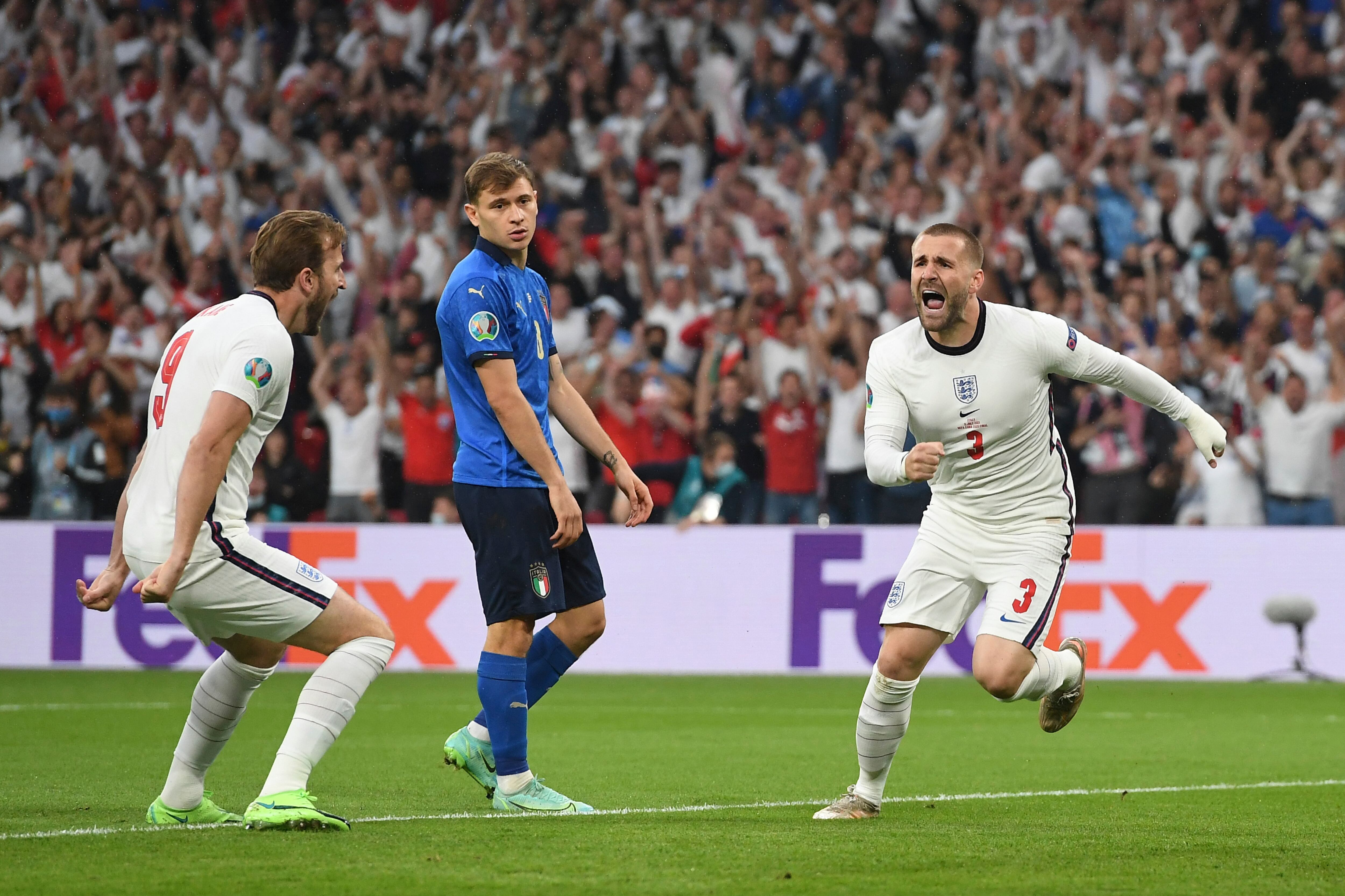 England's Luke Shaw, right, celebrates after scoring his side's opening goal during the Euro 2020 soccer final match between England and Italy at Wembley stadium in London, Sunday, July 11, 2021. (Andy Rain/Pool Photo via AP)