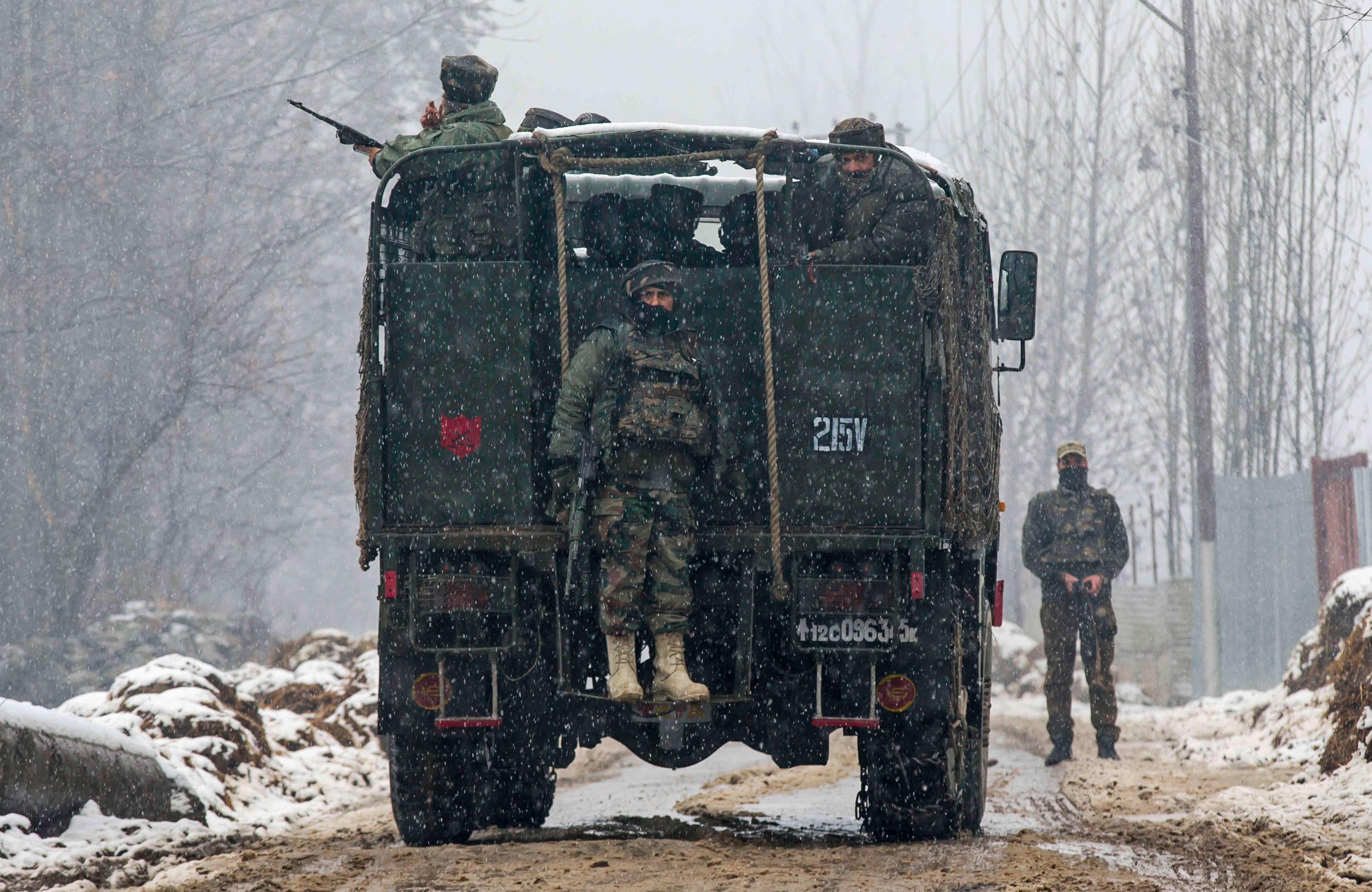 Los soldados del ejército indio están de guardia cerca del sitio de un tiroteo mientras nieva en Bakura, 20 kilómetros al noreste de Srinagar, Cachemira, el martes 24 de enero de 2017. Tres militantes fueron asesinados en la parte de Cachemira controlada por la India, dijo el ejército indio. (AP Foto / Dar Yasin)