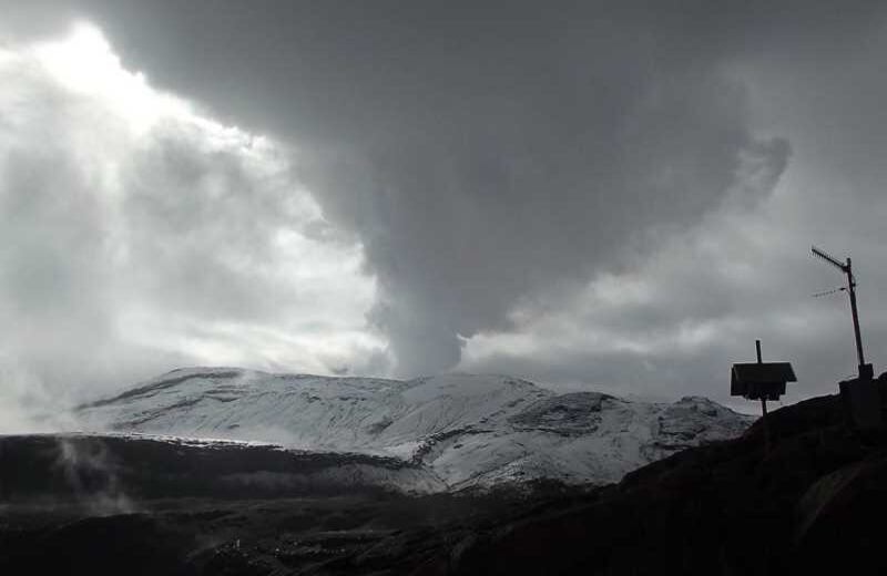 Columna de vapor y gases del volcán Nevado del Ruiz y equipo de monitoreo.