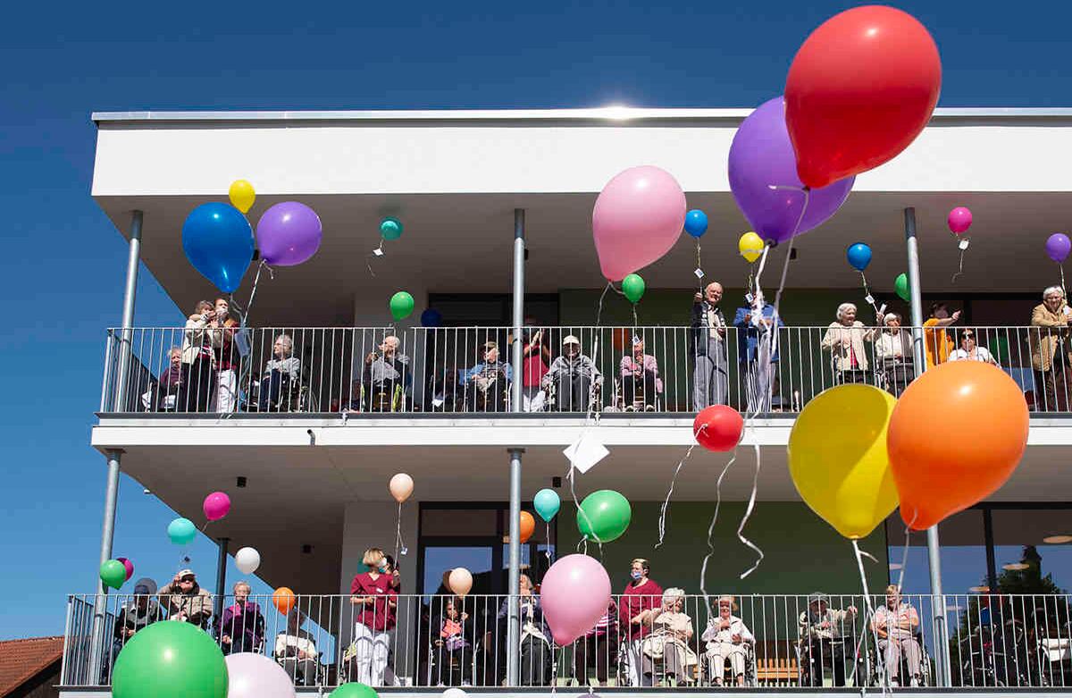 Los residentes de los hogares de ancianos, las enfermeras y los niños dejan volar globos durante un servicio de la iglesia protestante frente al Centro de Enfermería Schanzehof en Tiefenort, Alemania Central. Los globos llevan pequeñas cartas con diferentes deseos. A pesar de las restricciones de contacto coronavirus ordenados para las 77 personas que viven aquí, los residentes fueron capaces de celebrar el servicio juntos. Foto Jens Meyer / AP