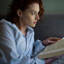 Retrato de perfil de mujer pelirroja en la lectura de la camisa del hombre.