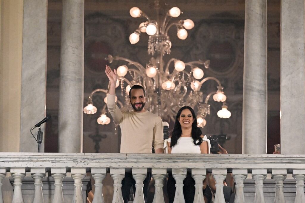 El presidente salvadoreño Nayib Bukele saluda a sus partidarios junto a su esposa Gabriela Rodríguez después de las elecciones presidenciales (Photo by Marvin RECINOS / AFP)