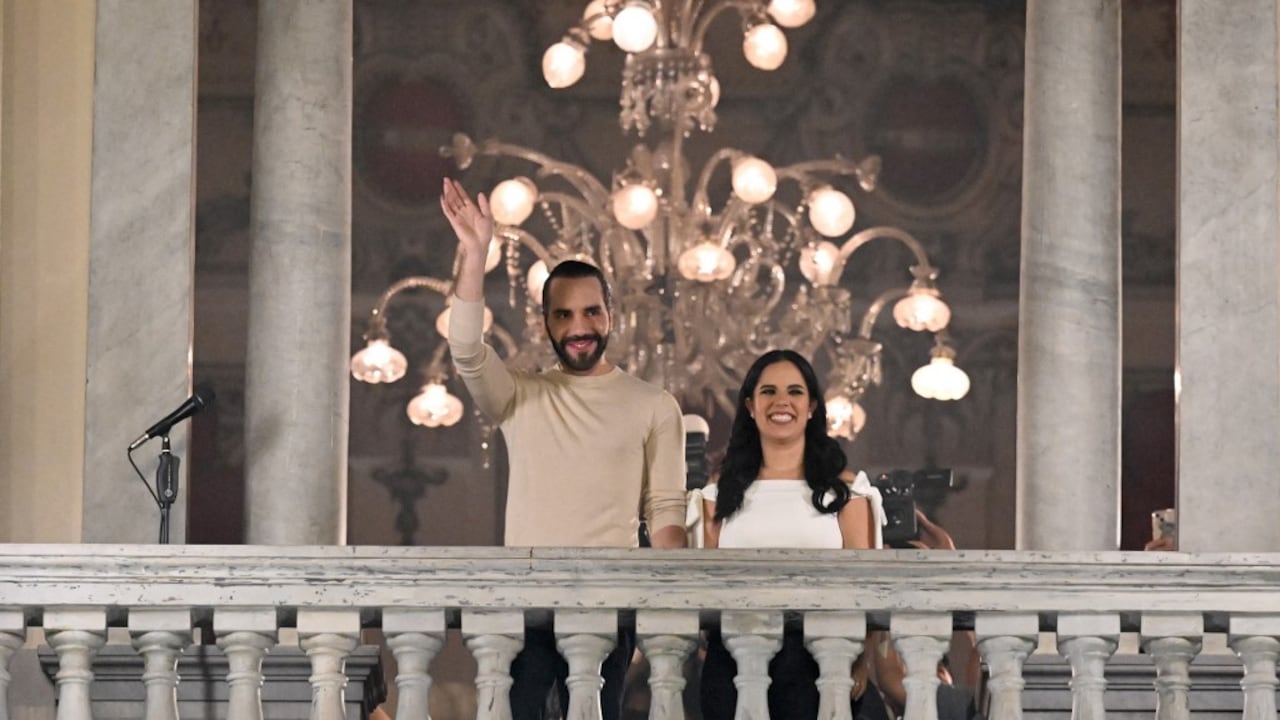 El presidente salvadoreño Nayib Bukele saluda a sus partidarios junto a su esposa Gabriela Rodríguez después de las elecciones presidenciales (Photo by Marvin RECINOS / AFP)