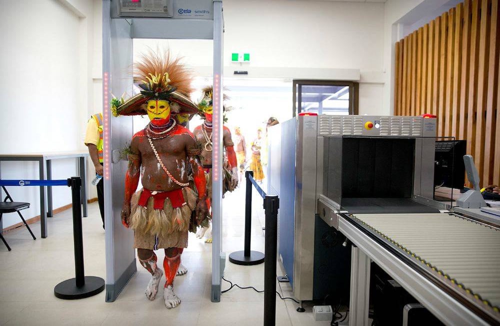 Los artistas con vestimenta tradicional pasan por un control de seguridad en el Aeropuerto Internacional Jacksons en Port Moresby, Papua Nueva Guinea, antes de la visita del vicepresidente de los EE. UU. Mike Pence, el sábado 17 de noviembre de 2018. (Foto AP / Mark Schiefelbein)