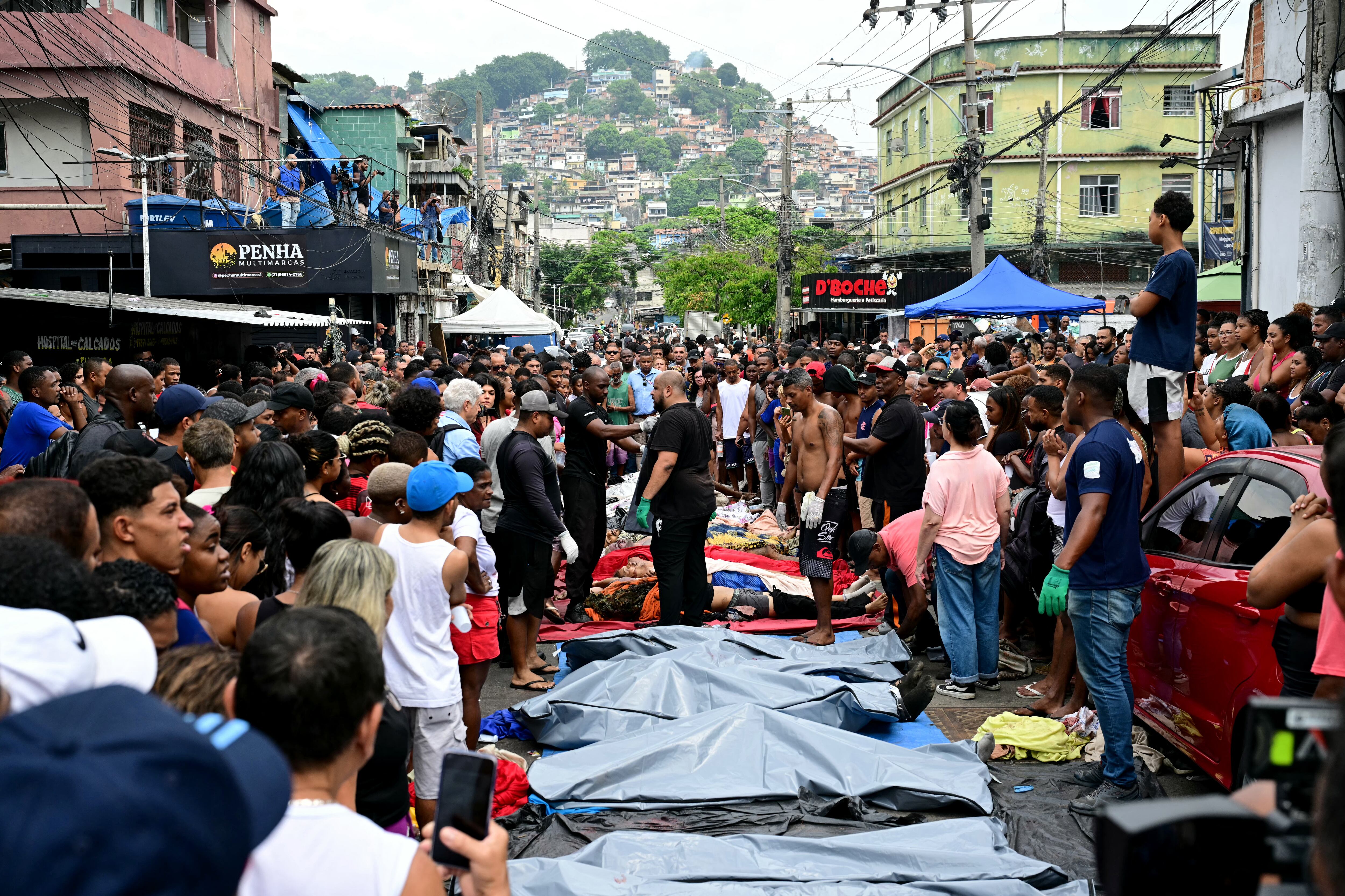 Residentes de una favela de Río de Janeiro alinearon más de 50 cuerpos en una plaza de Sao Lucas Square en Rio de Janeiro, luego de una operación que dejó más de 130 víctimas. (Photo by Pablo PORCIUNCULA / AFP)