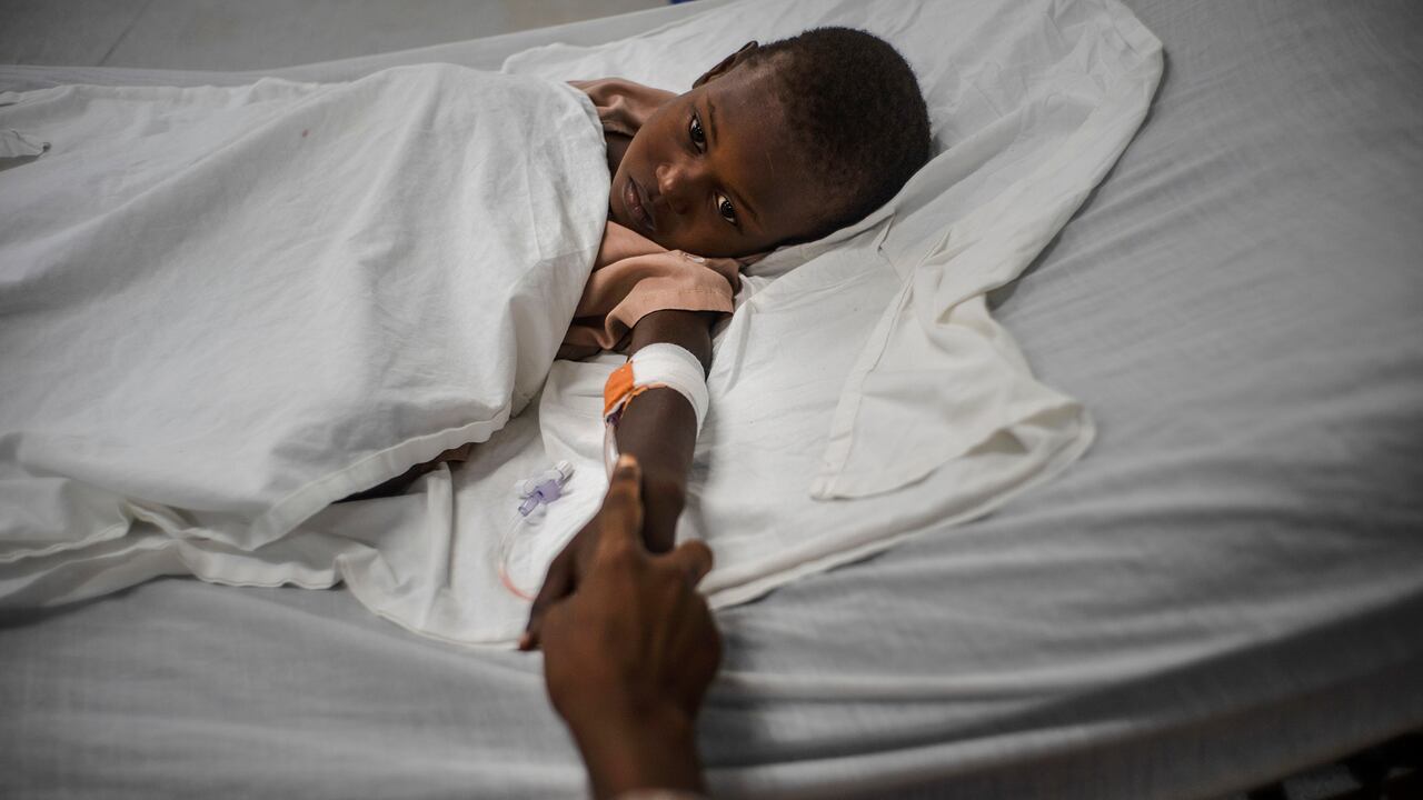 Rickson Beaubrun, quien resultó herido por una bala perdida mientras dormía en su cama en Cite Soleil, sostiene la mano de su hermana mientras se recupera en una clínica administrada por Médicos Sin Fronteras en el barrio Tabarre de Port-au-Prince, Haití, el jueves 11 de noviembre. 3 de enero de 2022.