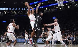 Cleveland Cavaliers' Evan Mobley, center left, and Brooklyn Nets' Andre Drummond, center right, vie for a rebound during the second half of the opening basketball game of the NBA play-in tournament, Tuesday, April 12, 2022, in New York. The Nets won 115-108. (AP Photo/Seth Wenig)