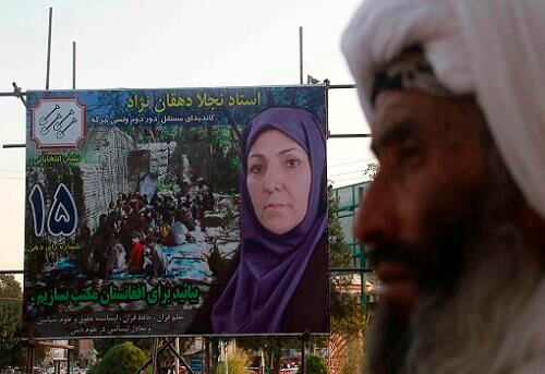 Un hombre camina junto a un cartel de la candidata al parlamento de Afganistán, Najla Dahqan, en Herat, Afganistán. Algunos carteles electorales de candidatas mujeres están siendo dañados por grupos afines a los talibanes. Las elecciones parlamentarias están previstas para el 18 de septiembre de 2010.
