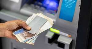 Unrecognizable man holding his debit card and cash after withdrawing from atm - Crad to edit