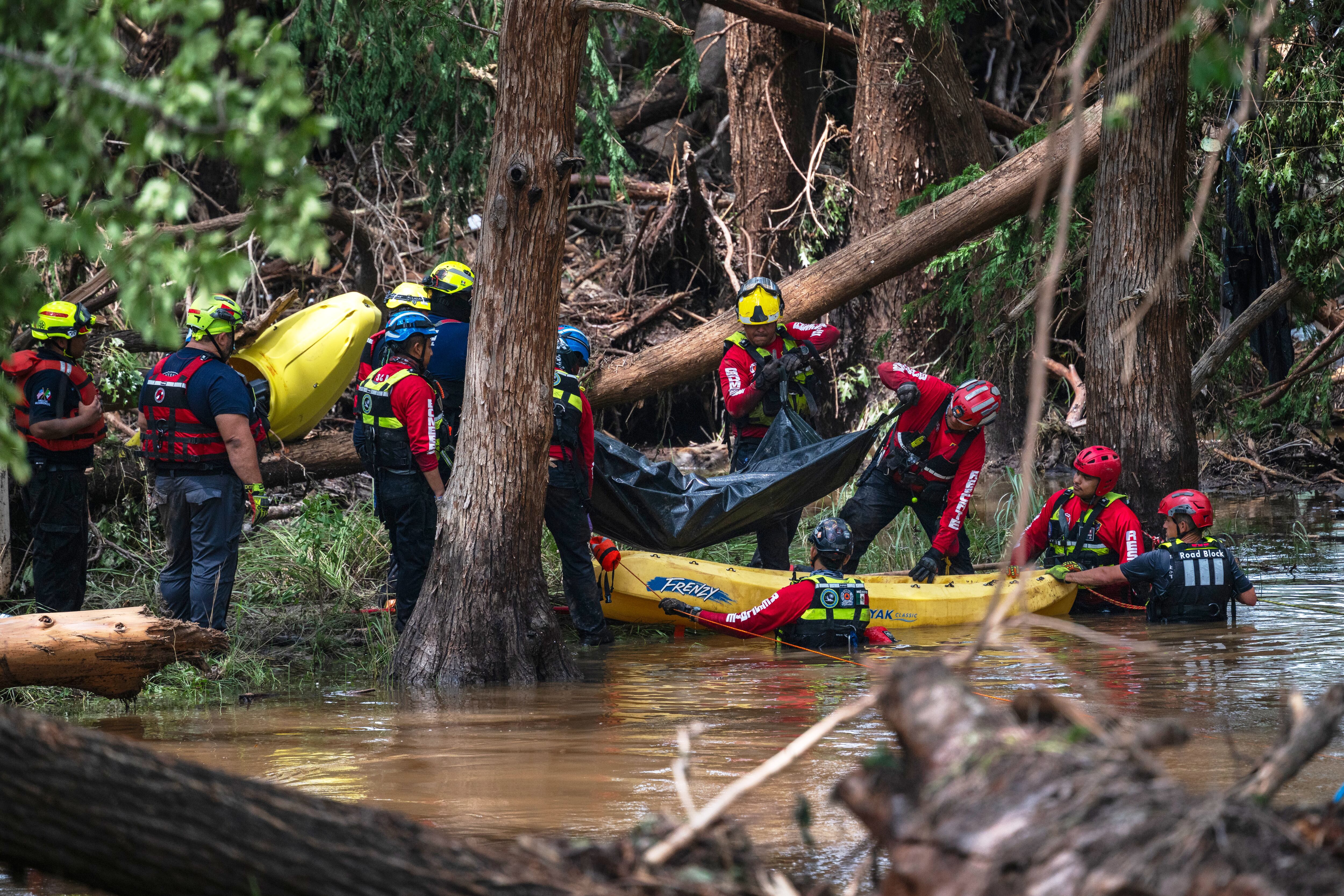 Un equipo de bomberos de Ciudad Acuna, a la izquierda, ayuda en los esfuerzos de búsqueda y rescate cerca del río Guadalupe después de que una inundación repentina barrió la zona el lunes 7 de julio de 2025 en Ingram, Texas. (AP Photo/Eli Hartman)