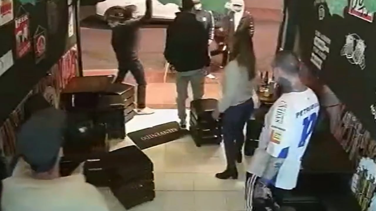 Los sujetos identificados con camiseta de Santa Fe lanzaron sillas y botellas al interior del establecimiento