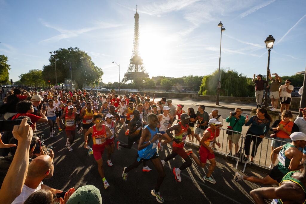 PARIS, FRANCE - AUGUST 10: Eliud Kipchoge of Team Kenya, Gabriel Gerald Geay of Team Tanzania, Jie He and Shahoui Yang of Team People's Republic of China run past Eiffel Tower during the Men's Marathon during day fifteen of the Olympic Games Paris 2024 at Esplanade Des Invalides on August 10, 2024 in Paris, France. (Photo by David Ramos/Getty Images)