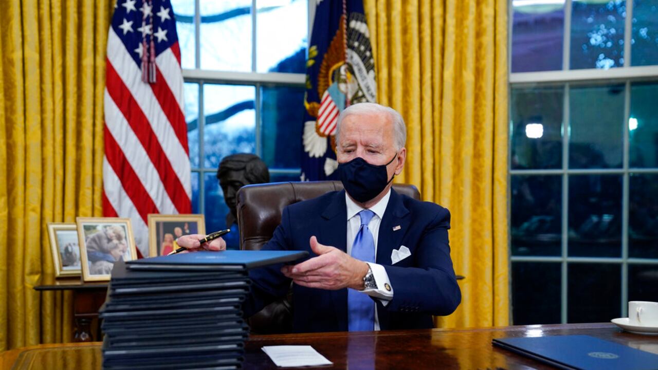 Joe Biden en el Salón Oval firmando varios decretos que revierten las políticas impuestas por Donald Trump.