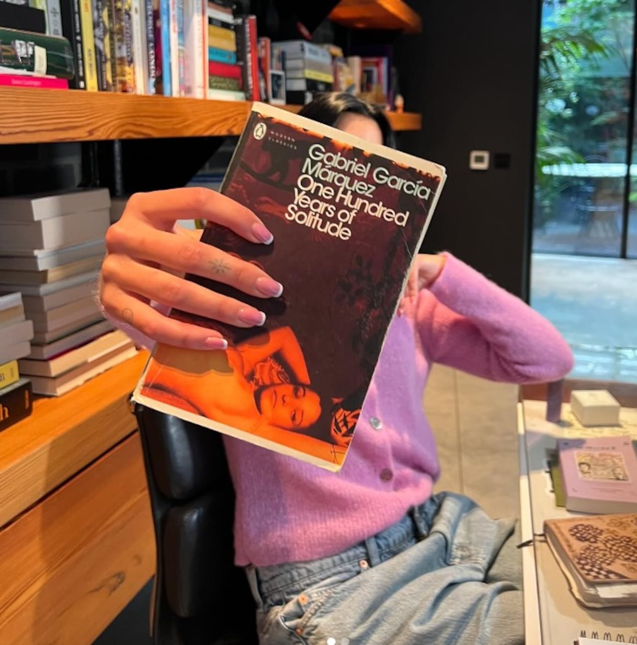 Dua Lipa mostrando Cien años de soledad.