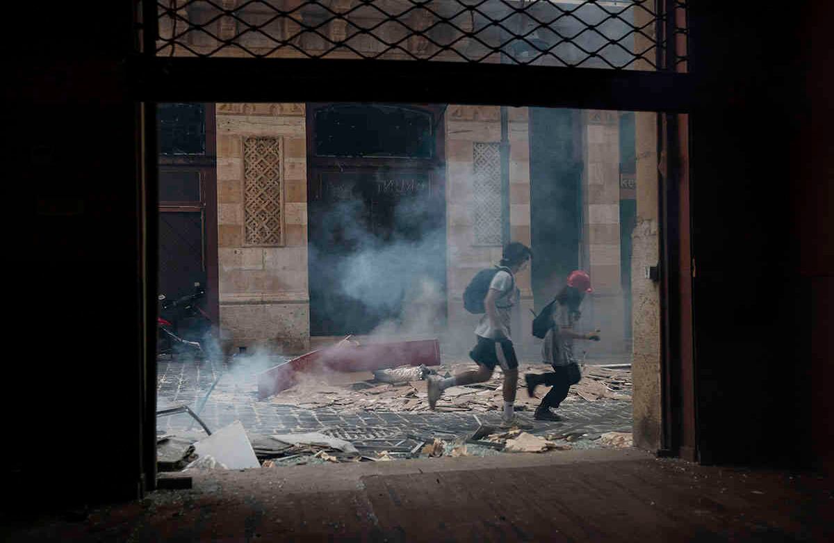 Los manifestantes huyen de los gases lacrimógenos disparados por la policía cerca del edificio del parlamento. AP Photo/Felipe Dana.