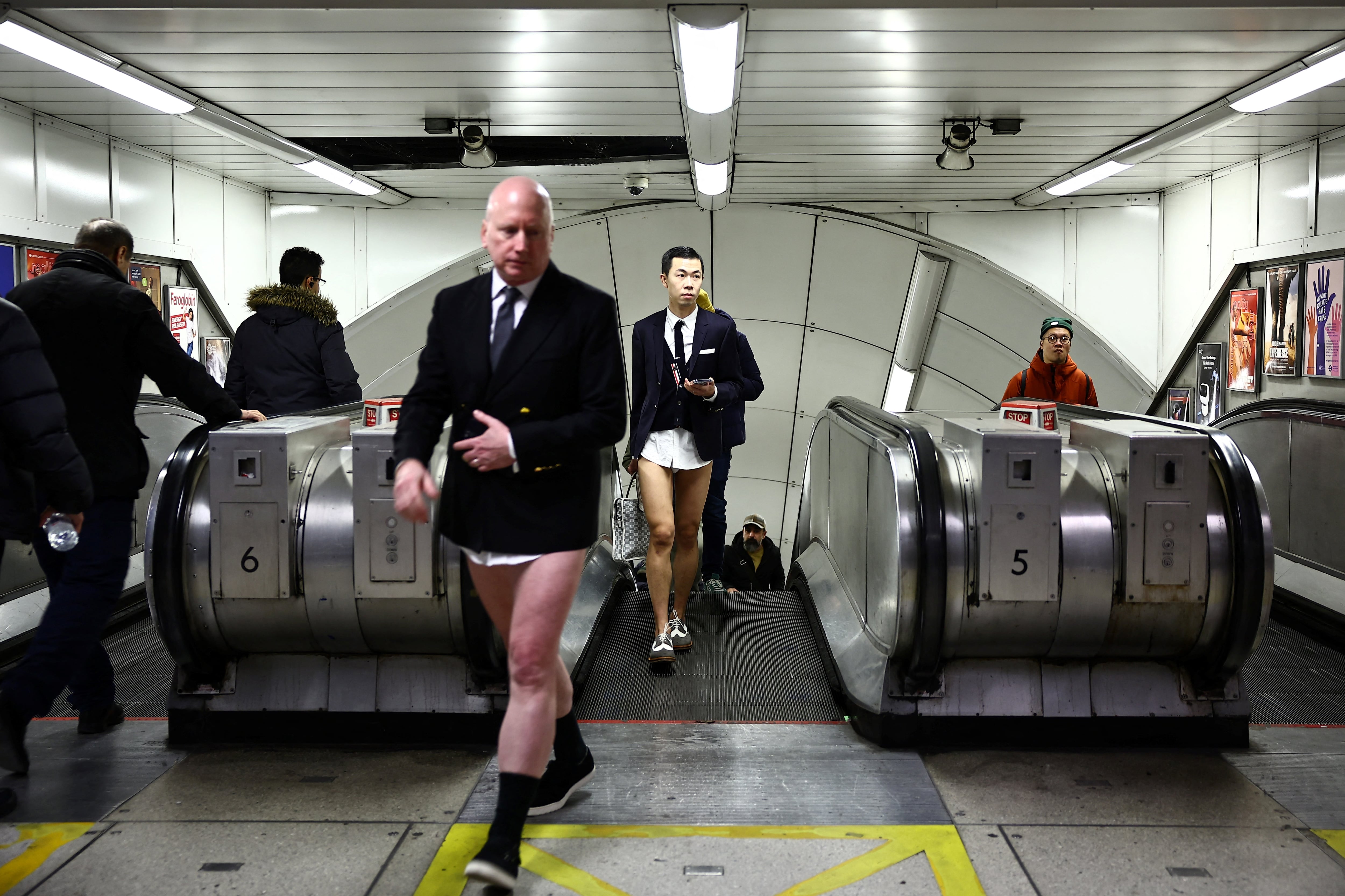 Las personas que participan en el "Día anual sin pantalones en el metro" (viaje en metro sin pantalones), caminan en una estación de metro del metro de Londres, en Londres, el 7 de enero de 2024.