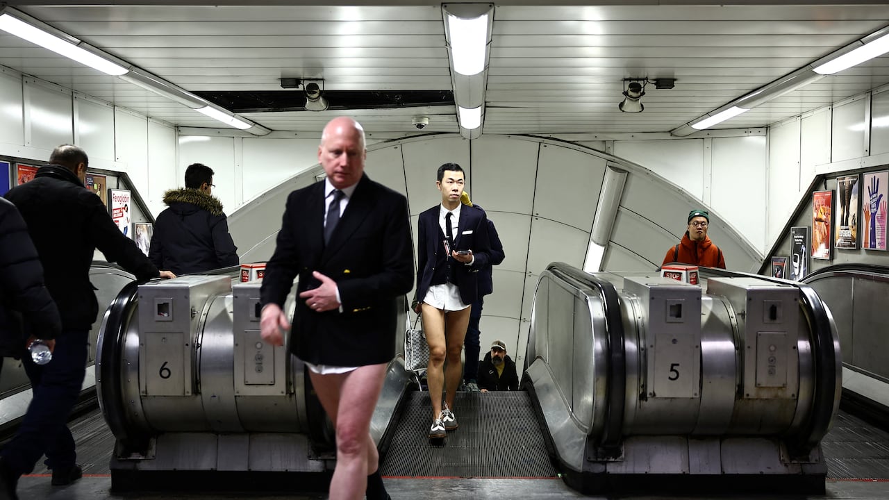 Las personas que participan en el "Día anual sin pantalones en el metro" (viaje en metro sin pantalones), caminan en una estación de metro del metro de Londres, en Londres, el 7 de enero de 2024.