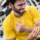 Hombre en el gimnasio entrena con una lesión en su brazo