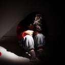 young girl sitting down alone in the dark.