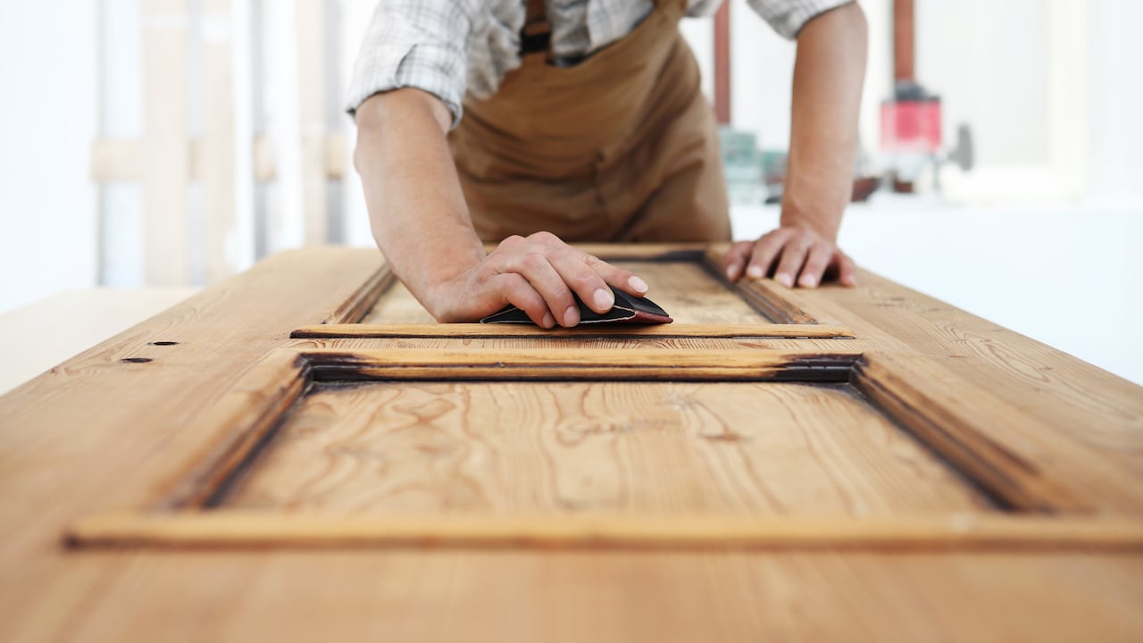 carpenter work the wood with the sandpaper