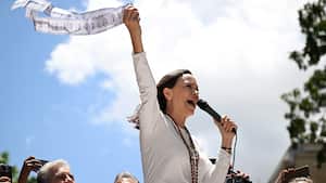 Venezuelan opposition leader Maria Corina Machado speaks to supporters while holding up electoral records during a rally in Caracas on August 28, 2024. Venezuela's opposition supporters rallied on August 28, a month after the disputed re-election of President Nicolas Maduro, who armoured his cabinet with a strongman at the helm of law and order. (Photo by JUAN BARRETO / AFP)