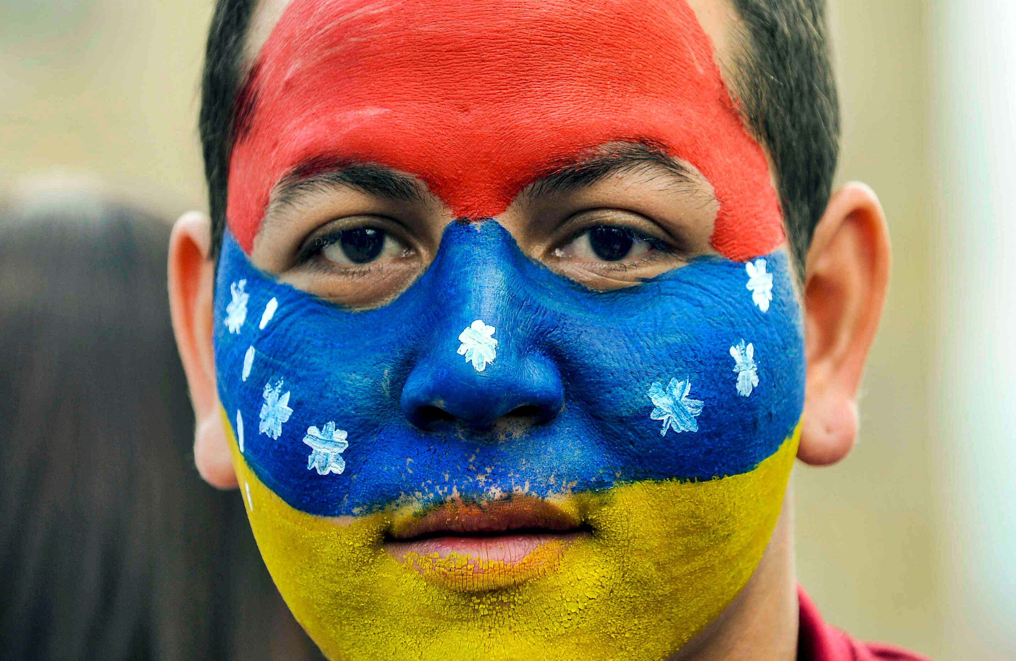 Un ciudadano venezolano —residente en Bogotá— con la bandera de su país pintada en su rostro (al revés en señal de protesta)  hace fila para sufragar, en la Plaza de Bolívar, el domingo 16 de julio de 2017, en Colombia, durante las votaciones al plebiscito. Esta jornada democrática ha sido  impulsada  por la oposición al gobierno de Nicolás Maduro. En las tarjetas, los ciudadanos deben responder ‘sí’ o ‘no’ a tres preguntas: la primera es si respalda el plan del presidente Nicolás Maduro de cambiar la Constitución; la segunda es si  apoya la intervención de las Fuerzas Armadas para “restituir el orden constitucional” y por último si desea un gobierno de unidad nacional. Foto: Carlos Julio Martínez / SEMANA