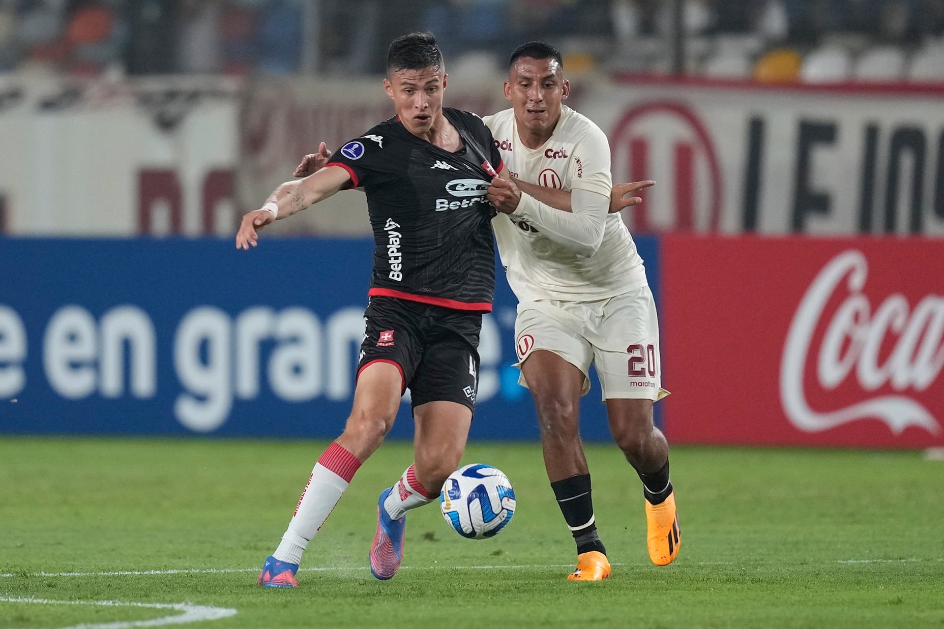 David Ramirez of Colombia's Independiente Santa Fe, left, and Alex Valera of Peru's Universitario, compete for the ball during a Copa Sudamericana group G soccer match at Monumental stadium in Lima, Peru, Thursday, May 4, 2023. (AP Photo/Martin Mejia)