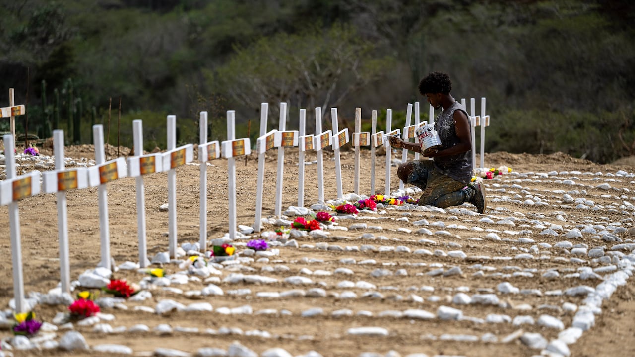 Un trabajador pinta tumbas para víctimas no identificadas del terremoto del 24 de junio en el cementerio La Esperanza, en Catia La Mar, estado La Guaira.