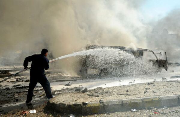 Un bombero intenta extinguir las llamas de un carro después de la explosión que sacudió a Damasco, la capital de siria. (AP)