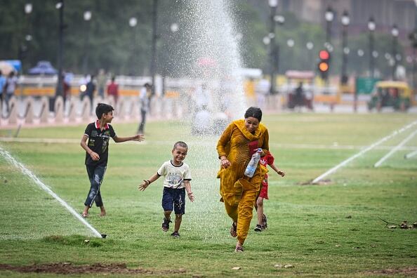 Turistas vistos durante el clima cálido y húmedo en Central Vista Lawns cerca de India Gate el 24 de junio de 2023 en Nueva Delhi, India. (Foto de Sanchit Khanna/Hindustan Times a través de Getty Images)
