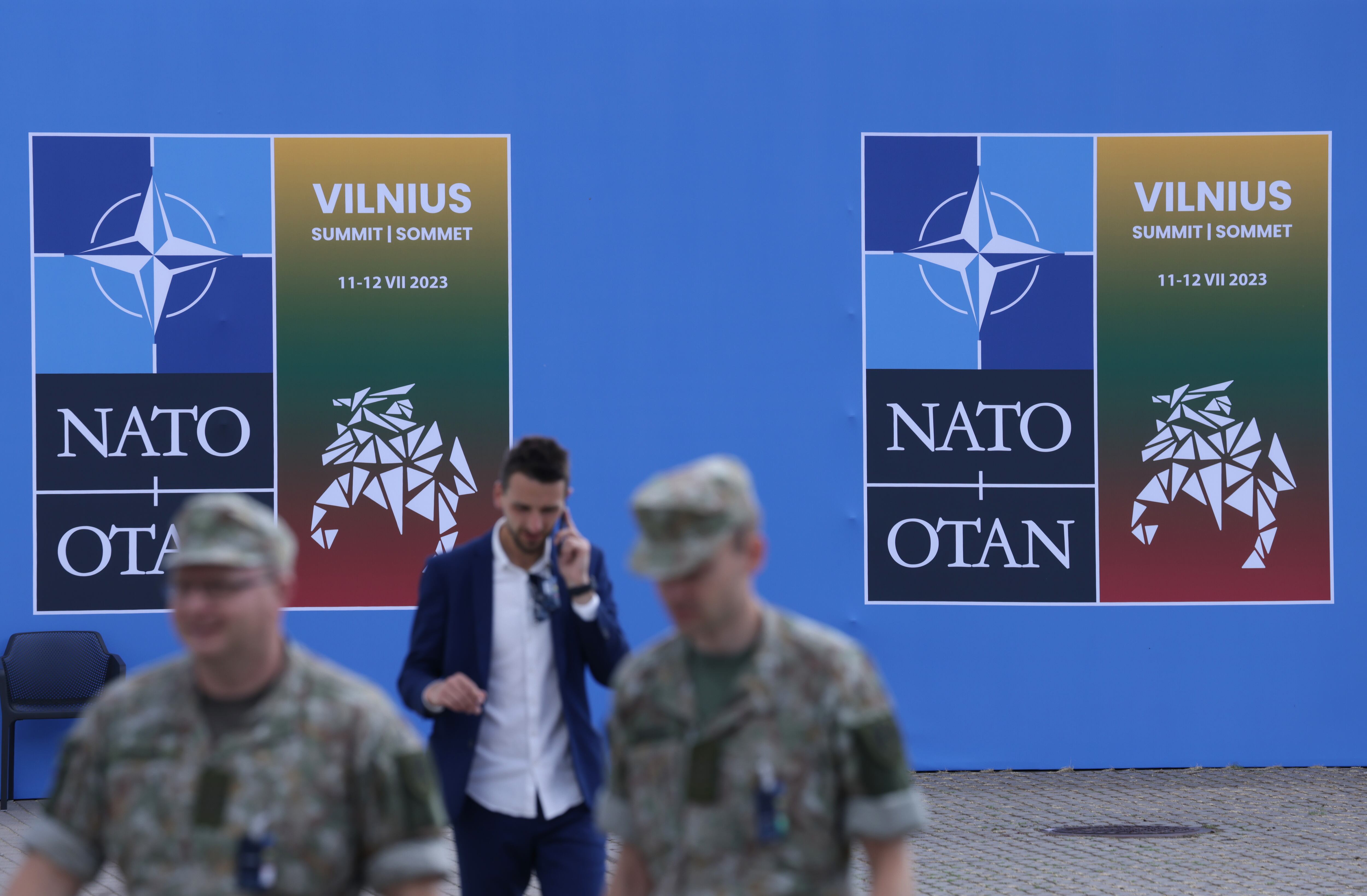 Los soldados pasan junto a un cartel en el lugar de la cumbre de la OTAN el 9 de julio de 2023 en Vilnius, Lituania