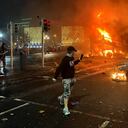 Flames rise from a car and a bus, set alight at the junction of Bachelors Walk and the O'Connell Bridge, in Dublin on November 23, 2023, as people took to the streets in protest following the stabbings earlier in the day. Protesters in Dublin on Thursday torched a car and fought police, an AFP journalist reported, after three children were injured in a suspected school stabbing that social media rumours attributed to a foreign national. (Photo by Peter MURPHY / AFP)