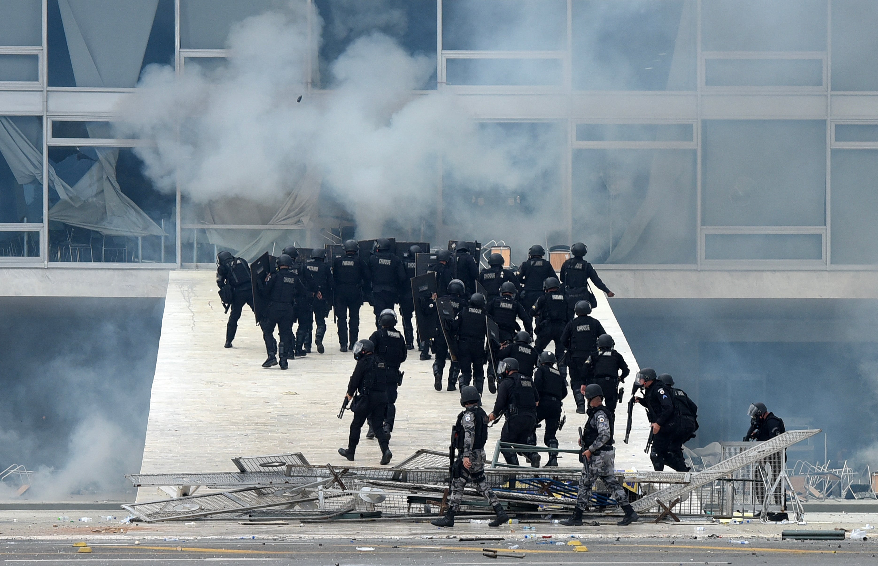 En esta foto de archivo tomada el 8 de enero de 2023, las fuerzas de seguridad se enfrentan a los partidarios del expresidente brasileño Jair Bolsonaro que invadieron el Palacio Presidencial Planalto en Brasilia. - Un juez de la Corte Suprema de Brasil ordenó el 14 de abril de 2023 que el expresidente Jair Bolsonaro enfrentara un interrogatorio por los disturbios en la sede del poder por parte de sus partidarios el 8 de enero, el último atolladero legal para el líder de extrema derecha. (Foto por Ton MOLINA / AFP)