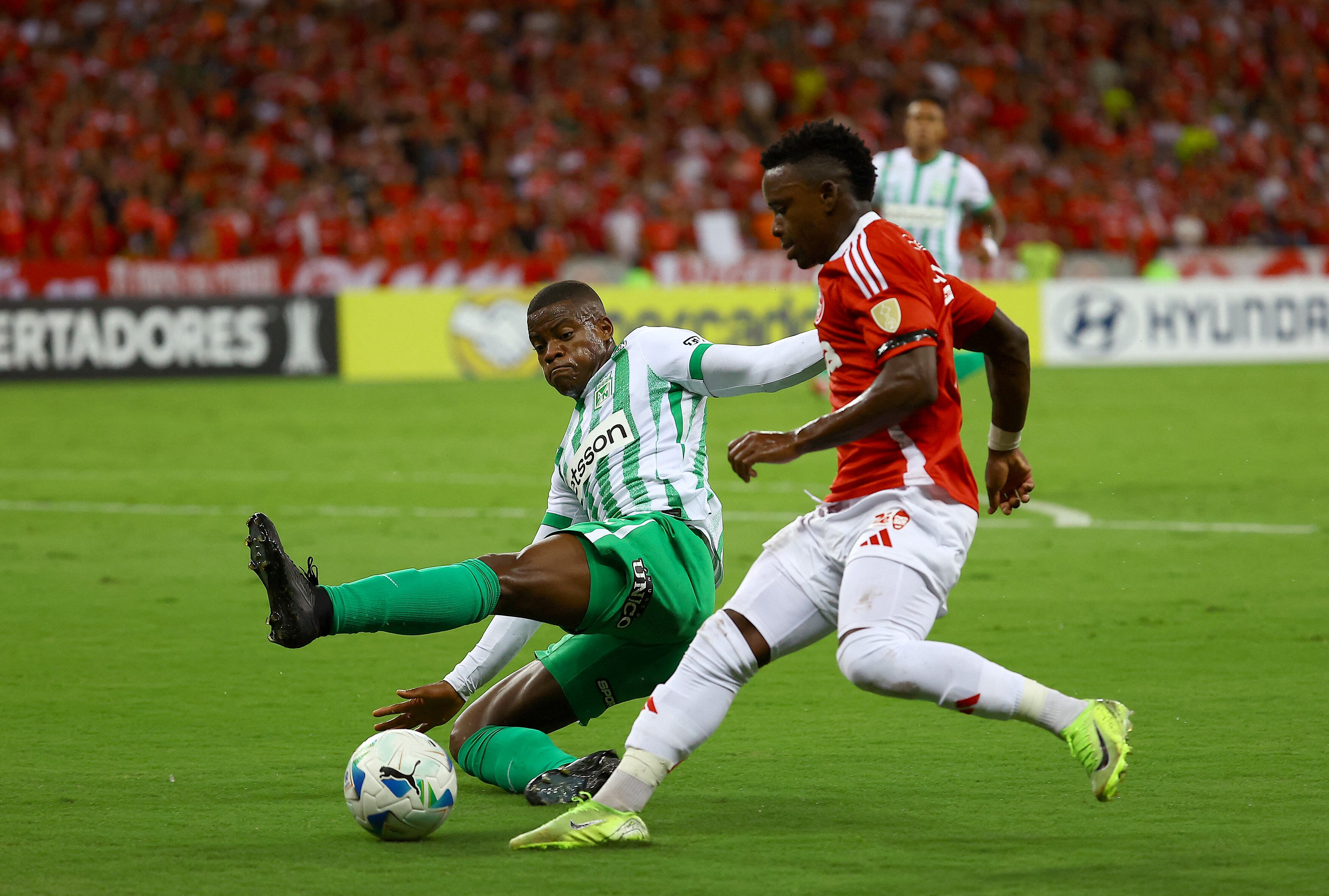 Atletico Nacional's defender #06 Andres Roman (L) and Internacional's Colombian forward #07 Johan Carbonero fight for the ball during the Copa Libertadores group stage football match between Brazil's Internacional and Colombia's Atletico Nacional at the Beira Rio stadium in Porto Alegre, Brazil, on April 10, 2025. (Photo by SILVIO AVILA / AFP)