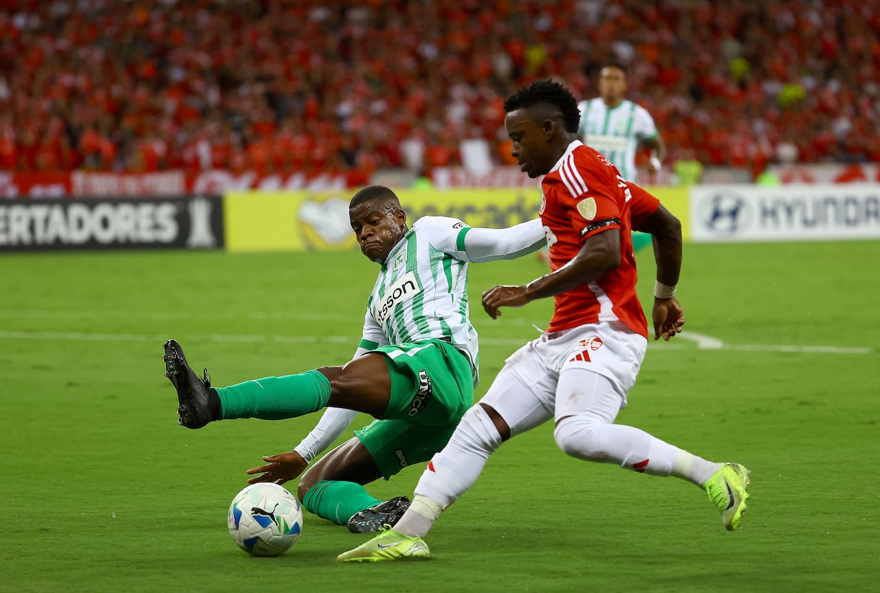 Atletico Nacional's defender #06 Andres Roman (L) and Internacional's Colombian forward #07 Johan Carbonero fight for the ball during the Copa Libertadores group stage football match between Brazil's Internacional and Colombia's Atletico Nacional at the Beira Rio stadium in Porto Alegre, Brazil, on April 10, 2025. (Photo by SILVIO AVILA / AFP)