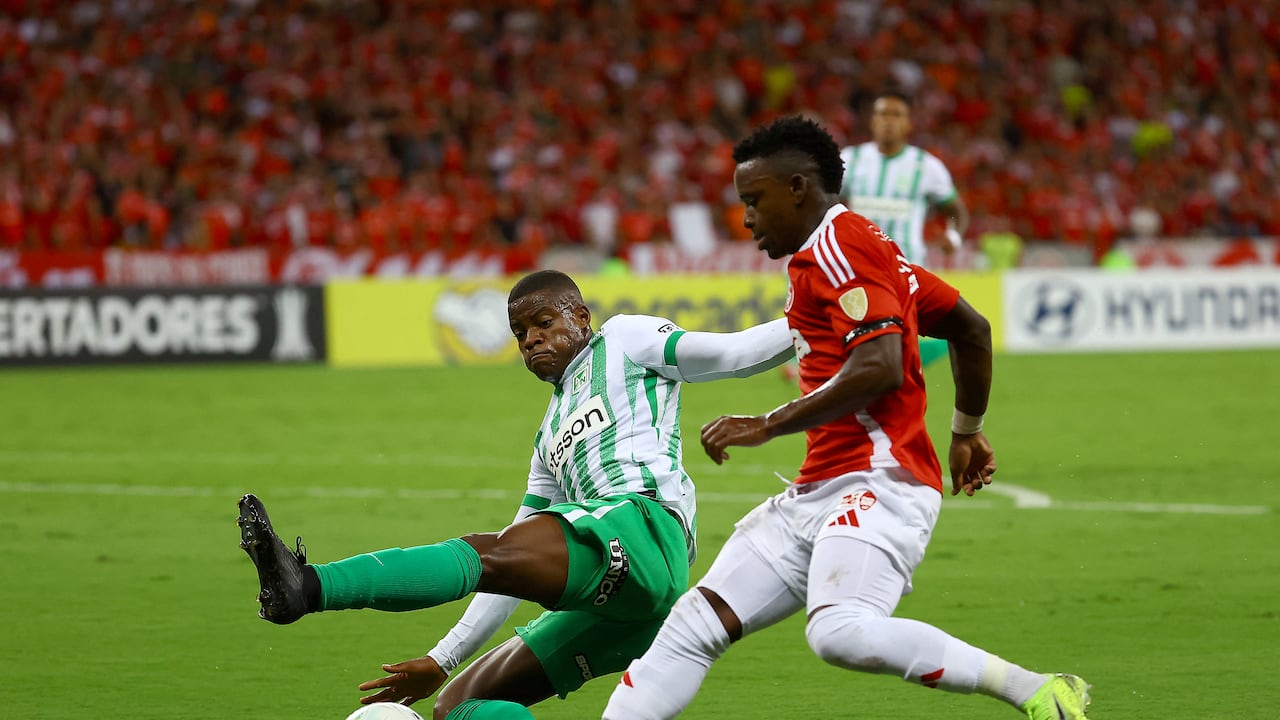 Atletico Nacional's defender #06 Andres Roman (L) and Internacional's Colombian forward #07 Johan Carbonero fight for the ball during the Copa Libertadores group stage football match between Brazil's Internacional and Colombia's Atletico Nacional at the Beira Rio stadium in Porto Alegre, Brazil, on April 10, 2025. (Photo by SILVIO AVILA / AFP)