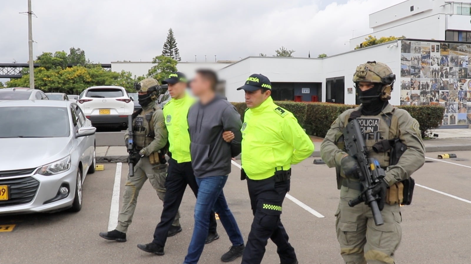 Policías custodian a presunto enlace del Cartel de Sinaloa en Colombia.