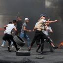 Palestinian protesters hurl rocks amid confrontations with Israeli security forces at the Hawara checkpoint south of Nablus city, in the occupied West Bank, on May 21, 2021, following demonstrations in support of Palestinians in Jerusalem's Sheikh Jarrah and the Gaza Strip. (Photo by JAAFAR ASHTIYEH / AFP)