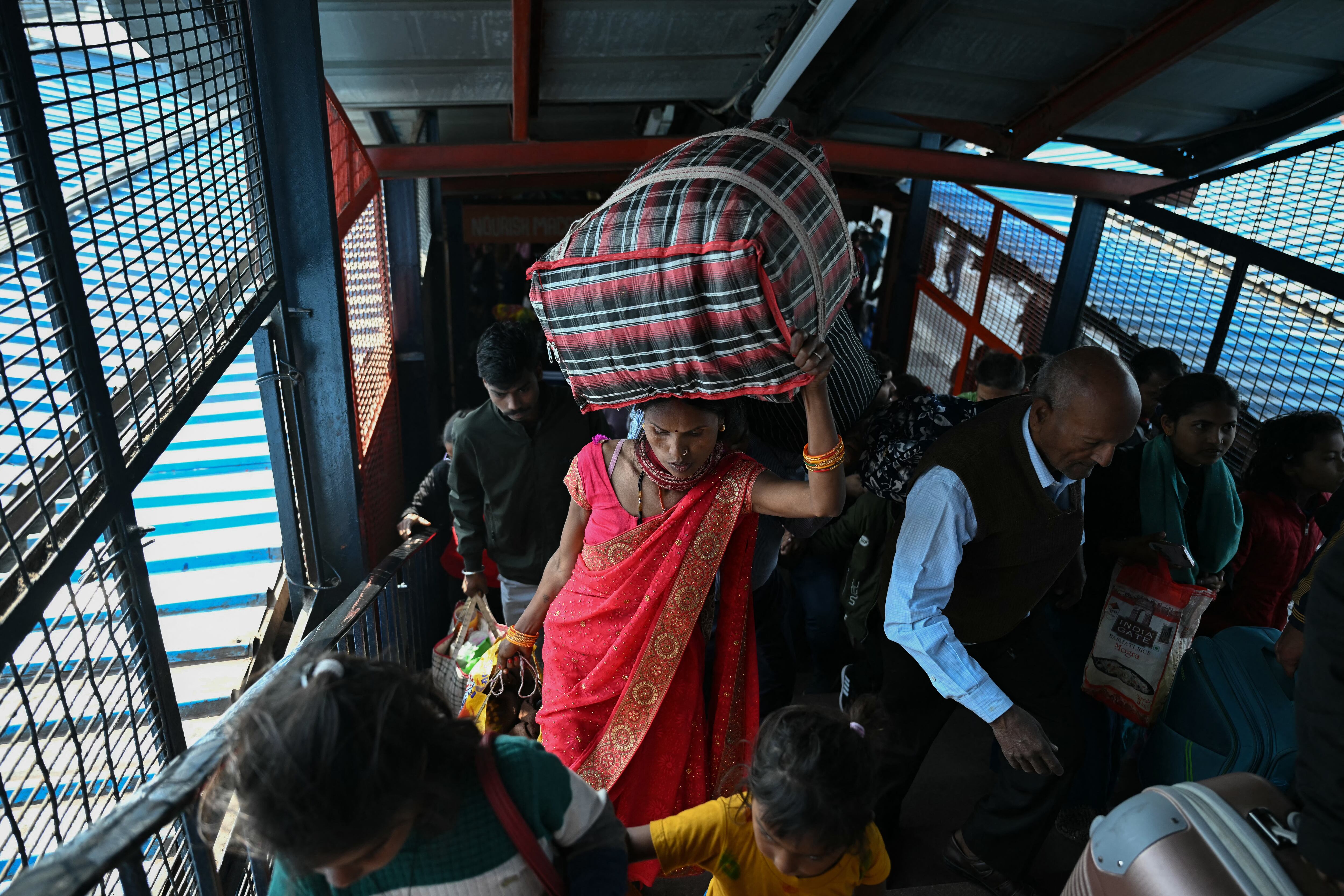 Passengers are pictured at the New Delhi railway station in New Delhi on February 16, 2025. At least 15 people died during a stampede at a railway station in India's capital late on February 15 when surging crowds scrambled to catch trains to the world's largest religious gathering, a medical official told AFP. (Photo by Sajjad HUSSAIN / AFP)
