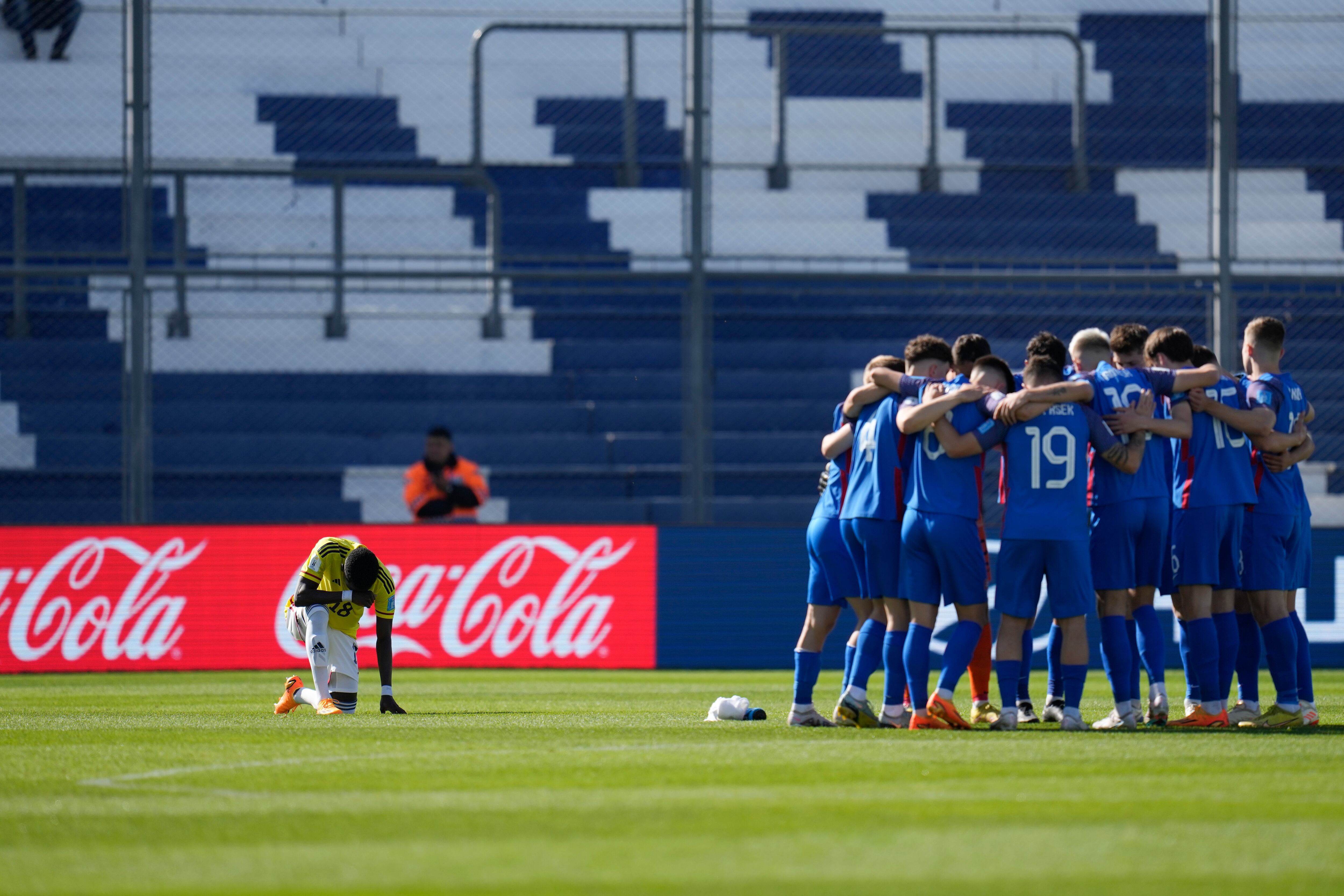 Colombia's Jhojan Torres, left, genuflects as Slovakia players gather prior to a FIFA U-20 World Cup round of 16 soccer match at the Bicentenario stadium in San Juan, Argentina, Wednesday, May 31, 2023. (AP Photo/Ricardo Mazalan)