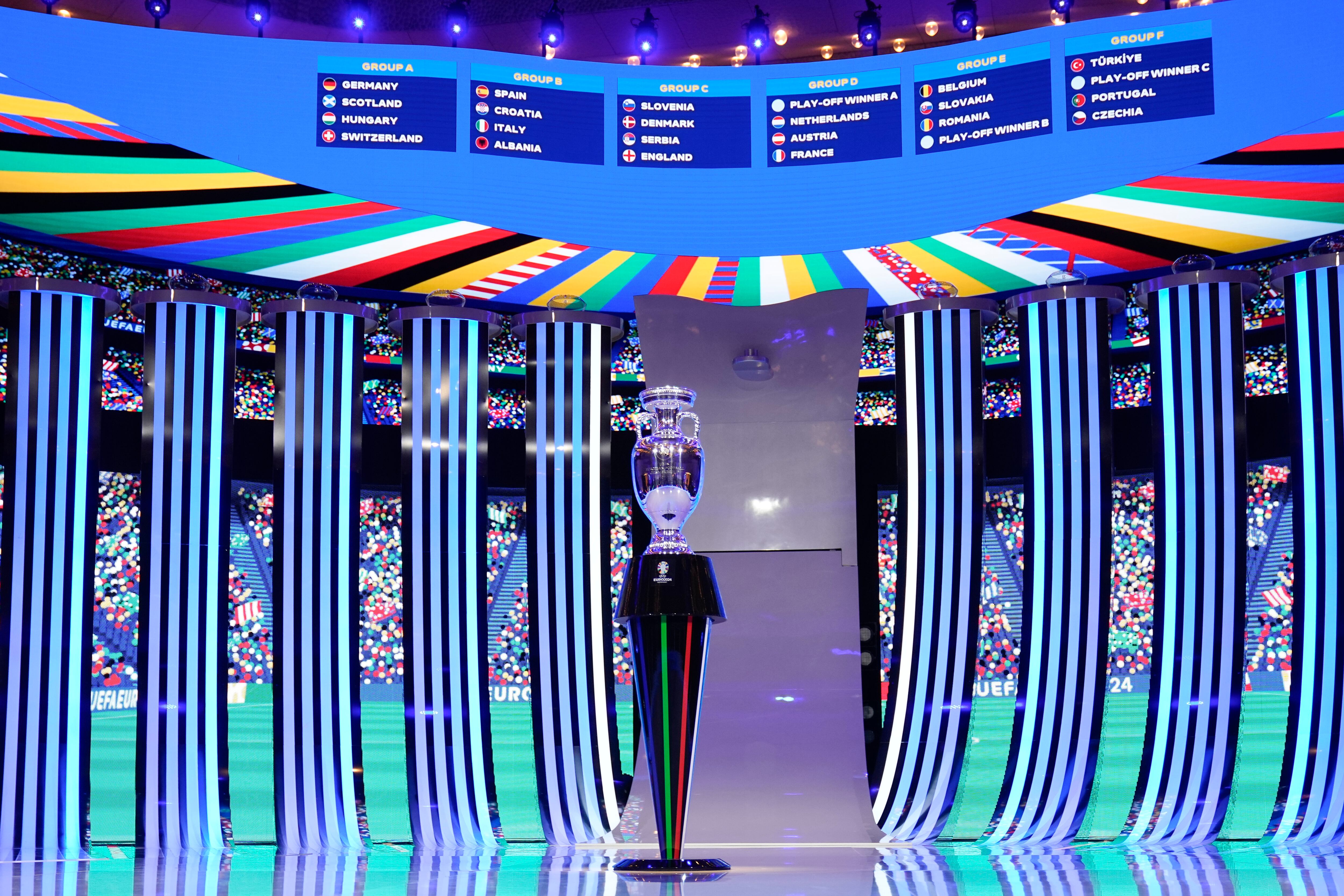 El trofeo colocado frente a un marcador que muestra el sorteo final, excepto los ganadores de los play-offs, después del sorteo de la final del torneo de fútbol UEFA Euro 2024 en Hamburgo, Alemania, el sábado 2 de diciembre de 2023. (Foto AP/Martin Meissner )
